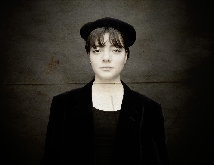 Elinor Grimmer - Black and white vintage feeling portrait of a young woman wearing all black.