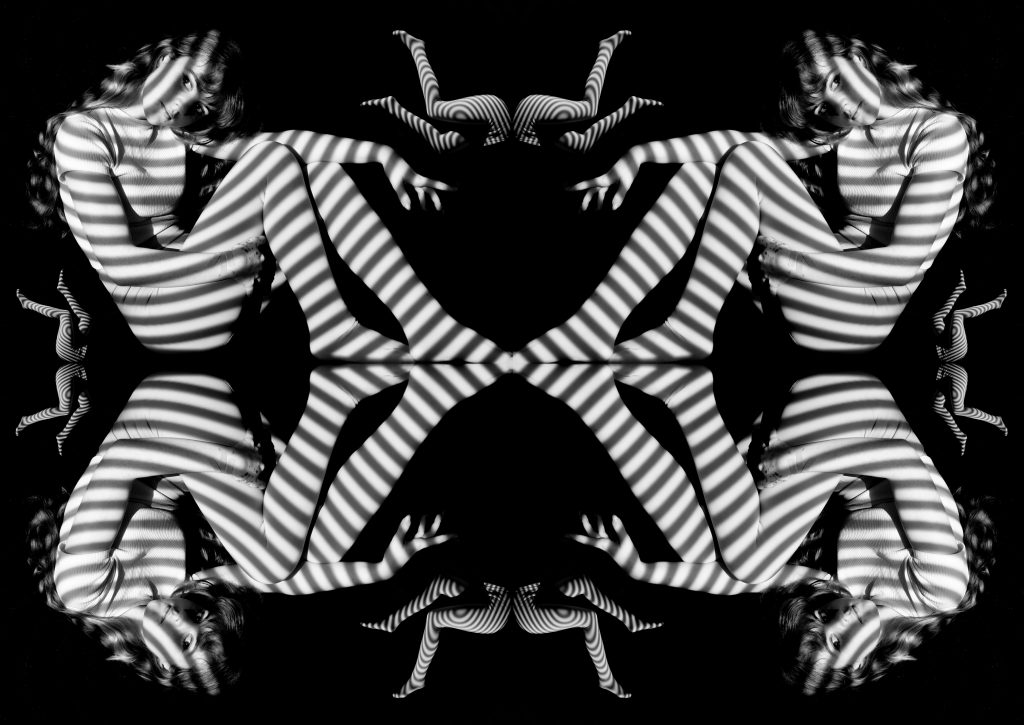 Eva-May Reeves - Black and white mirrored image of a sitting figure lit by striped of white light.